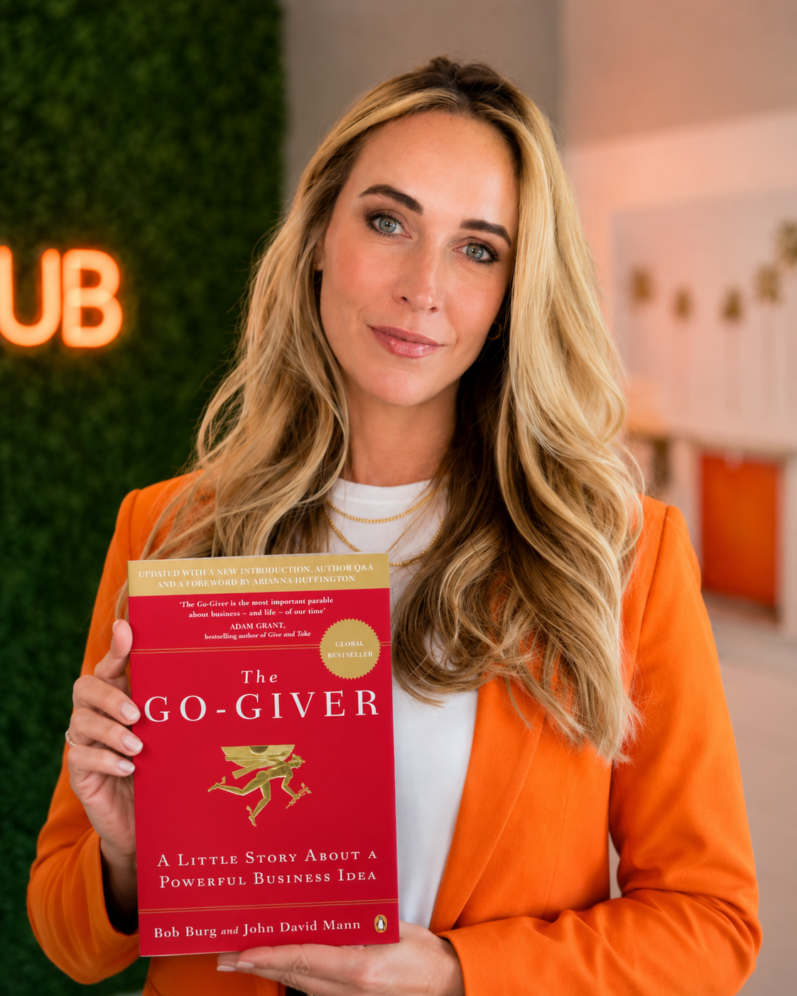 Jam Anderson, founder of Jam AI and Club Jam, holding a copy of The Go-Giver by Bob Burg
