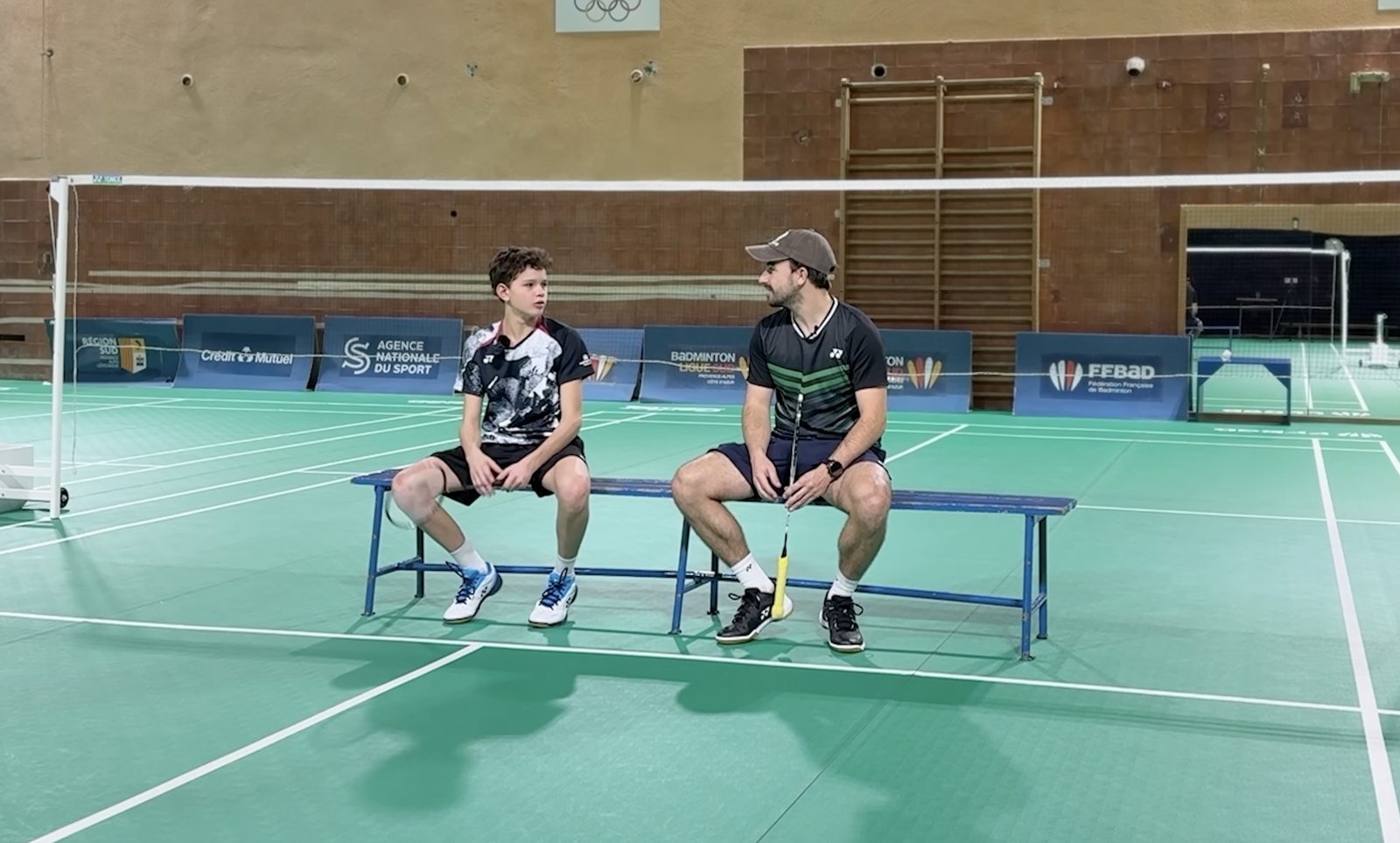 Antoine en interview avec un jeune joueur, dans une salle de ligue