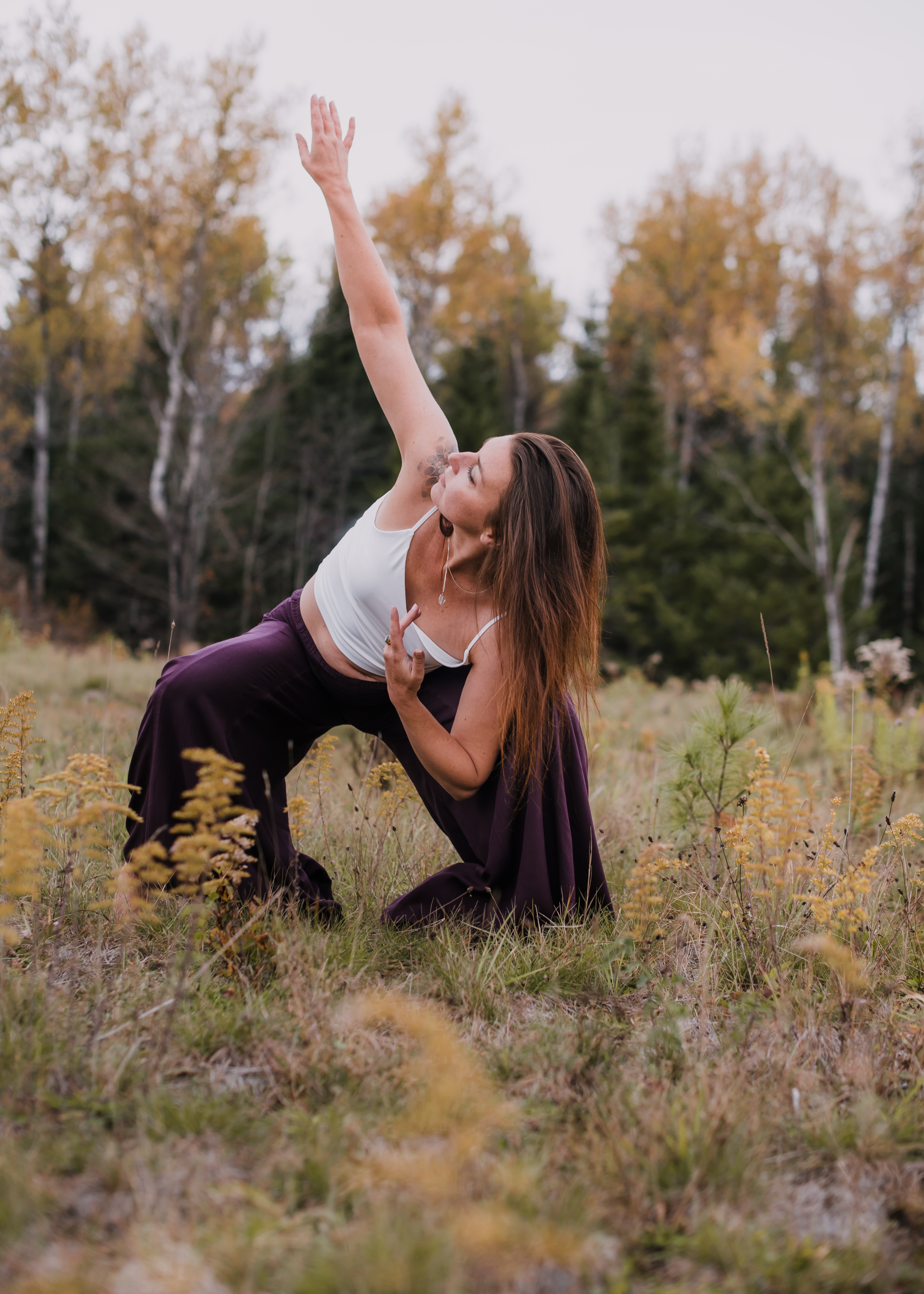 Marilyn moving in an autumn meadow, one arm reaching high toward the sky