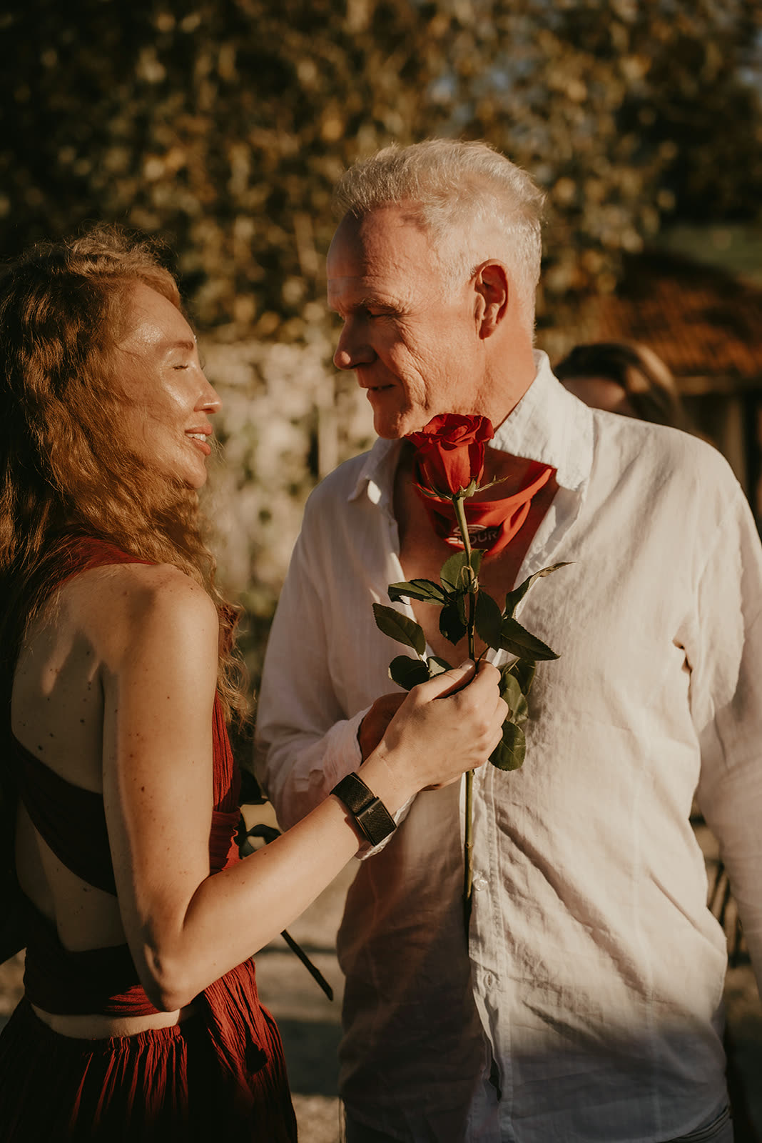 A woman offering a rose to a man during the closing ritual