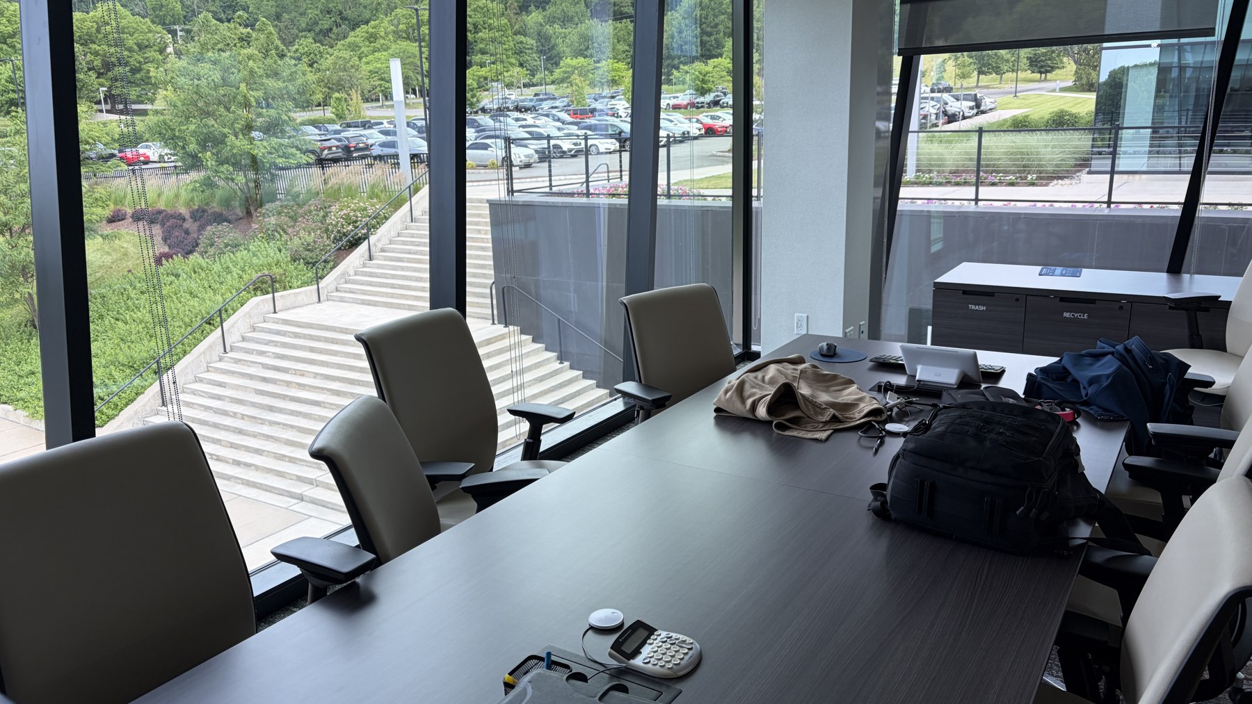 Wide behind-the-scenes view of a glass conference room before the interview lighting was completed