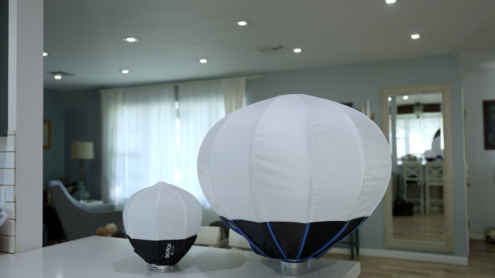 Compact Godox ML-CS30 lantern beside a much larger lantern with both fully opened
