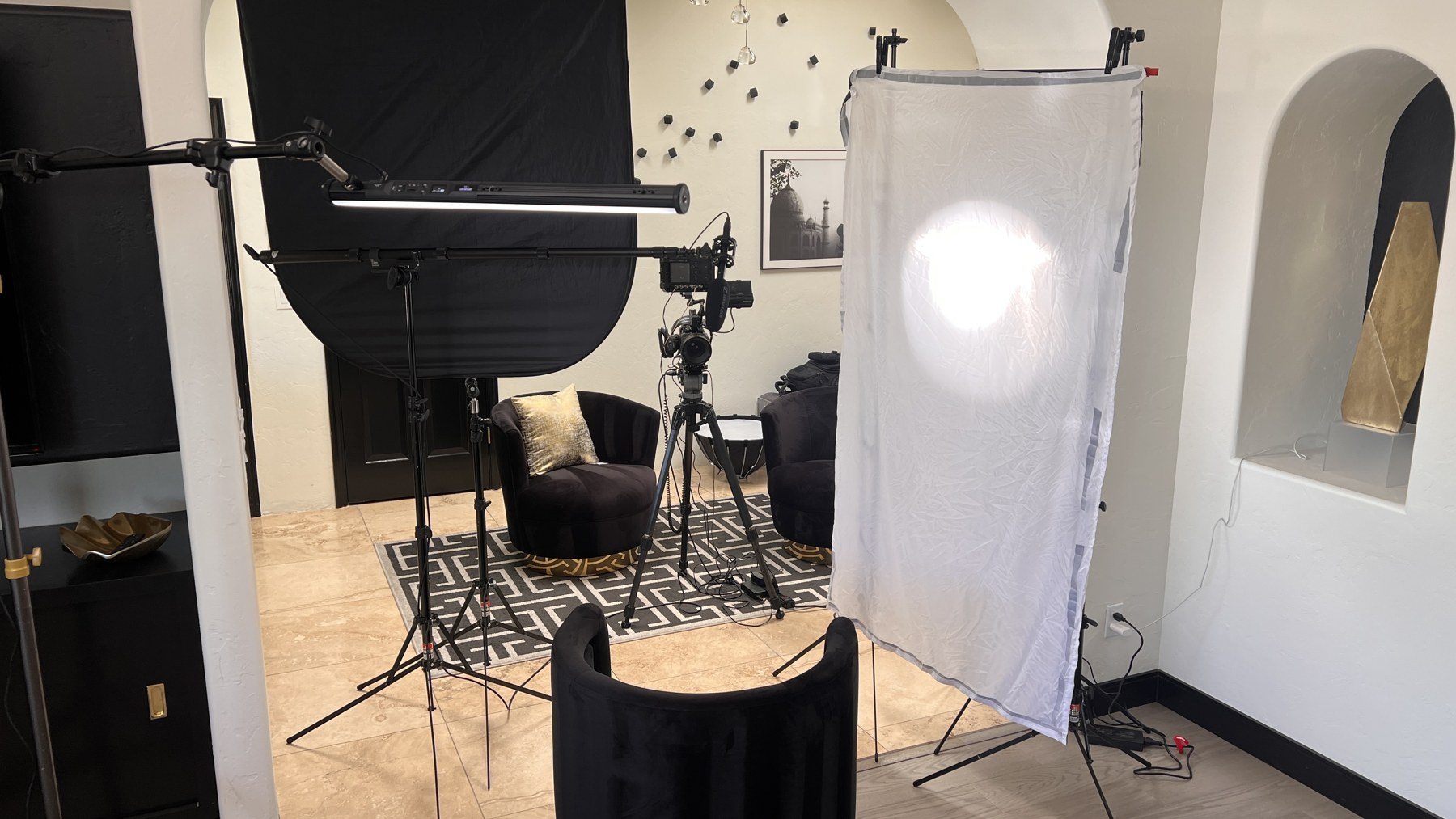 Reverse behind-the-scenes view showing the camera, diffusion frame, negative fill, and tube light for the first interview setup