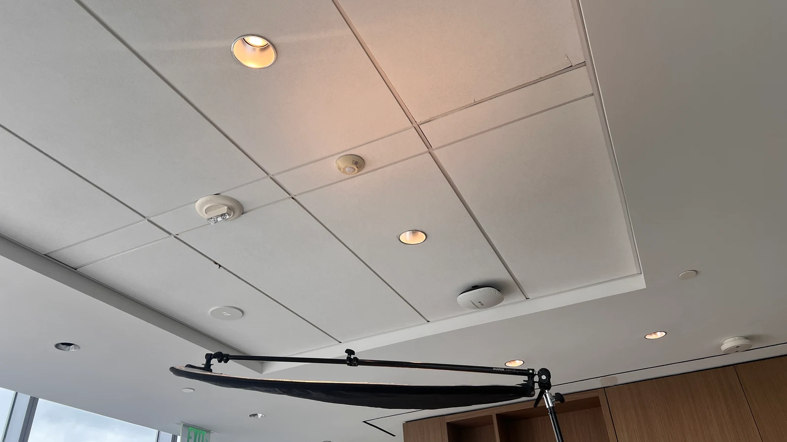 Black overhead flag positioned above an interview subject to block ceiling light