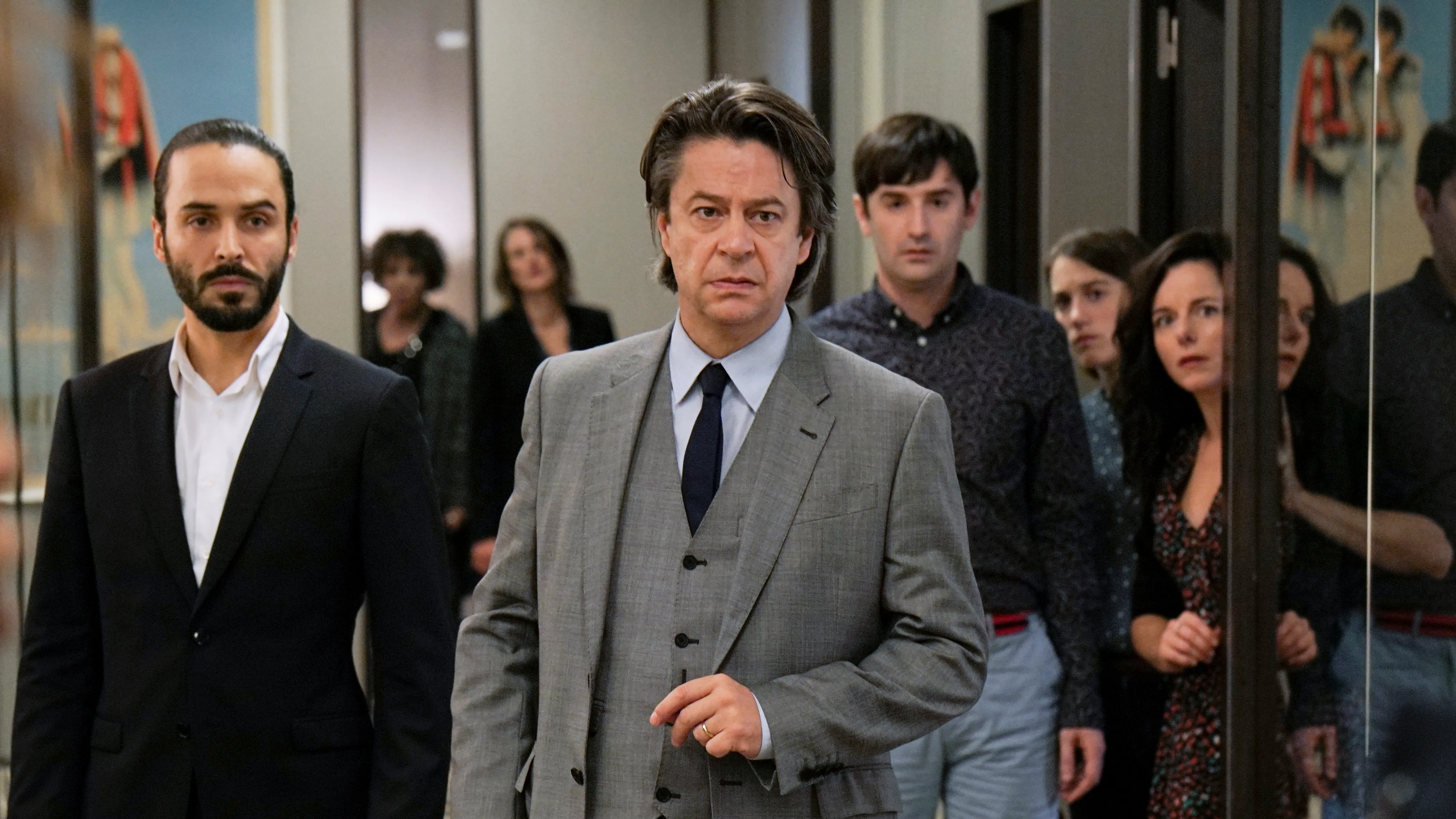 Cast members in a bright office scene from the Call My Agent television series