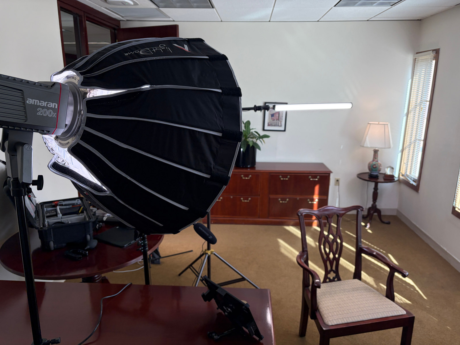 Behind-the-scenes view of an amaran 200x softbox and tube backlight in a corporate office interview setup