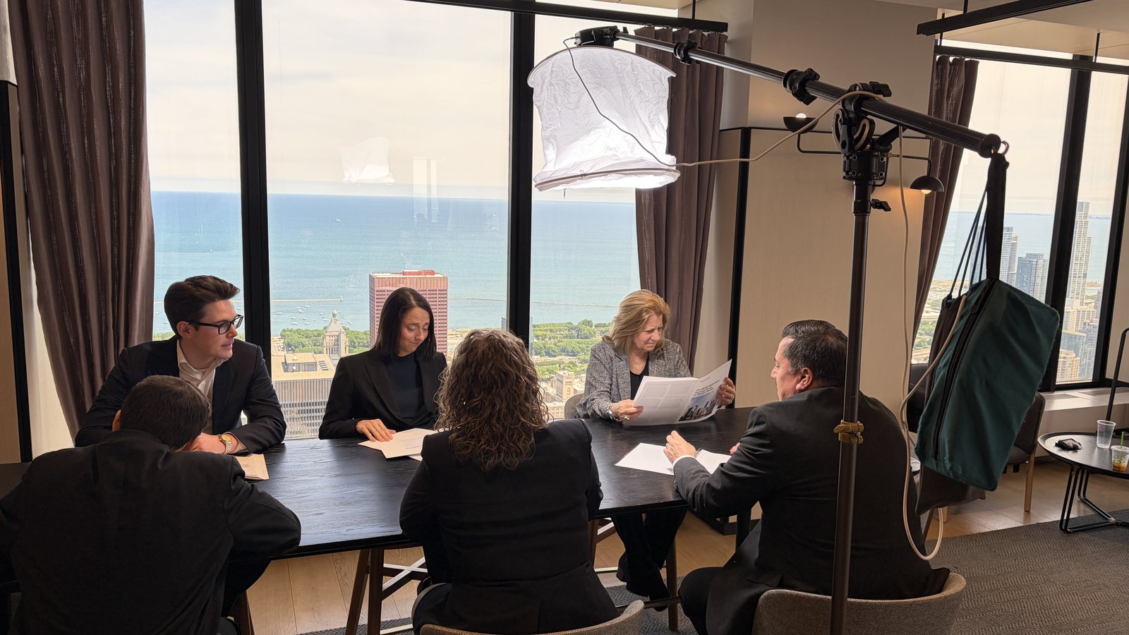 Corporate video crew using an overhead lantern to light a group around a table