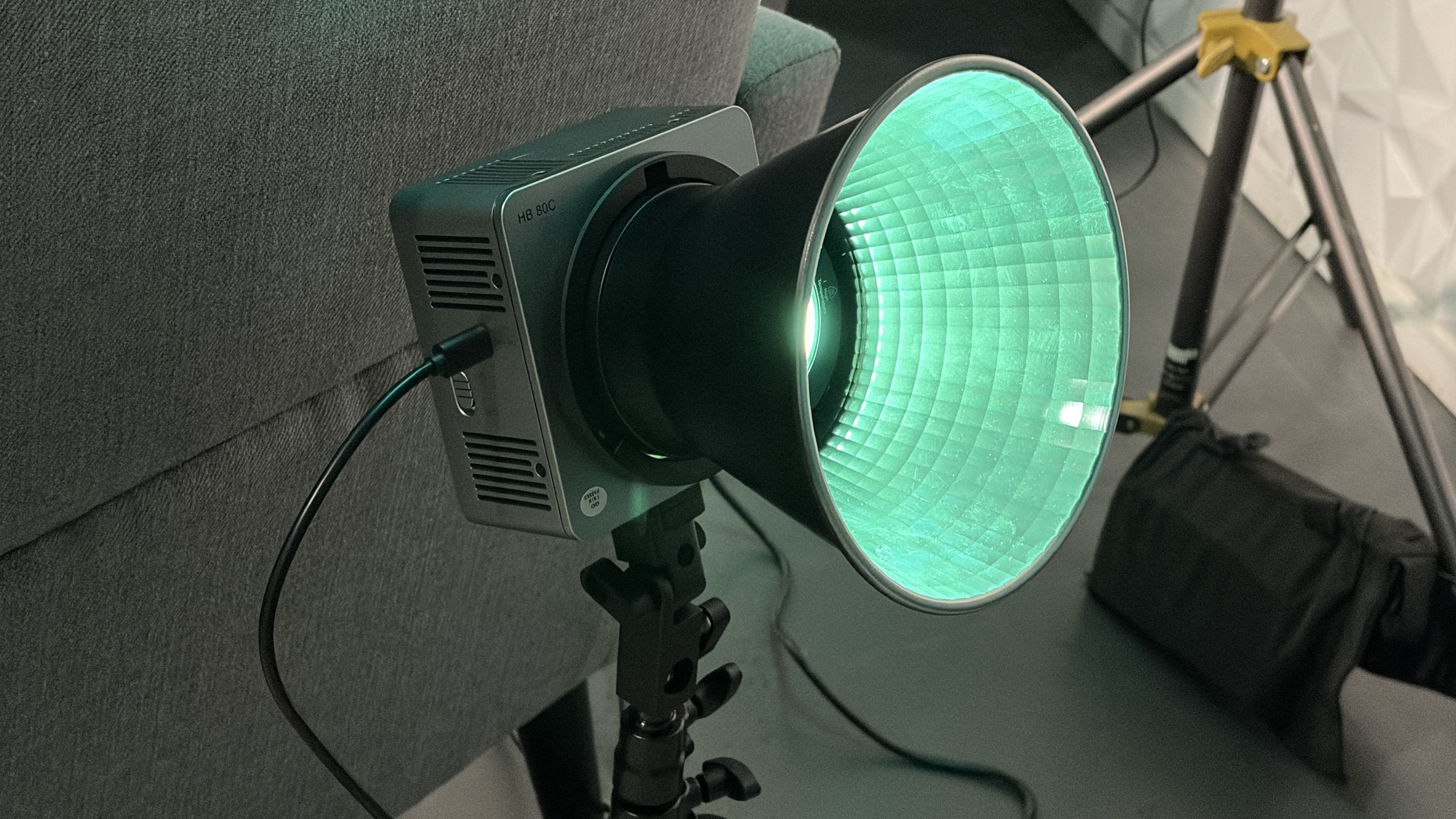 Neewer HB80C RGB fixture with reflector used to create a colored pool of light on the interview background