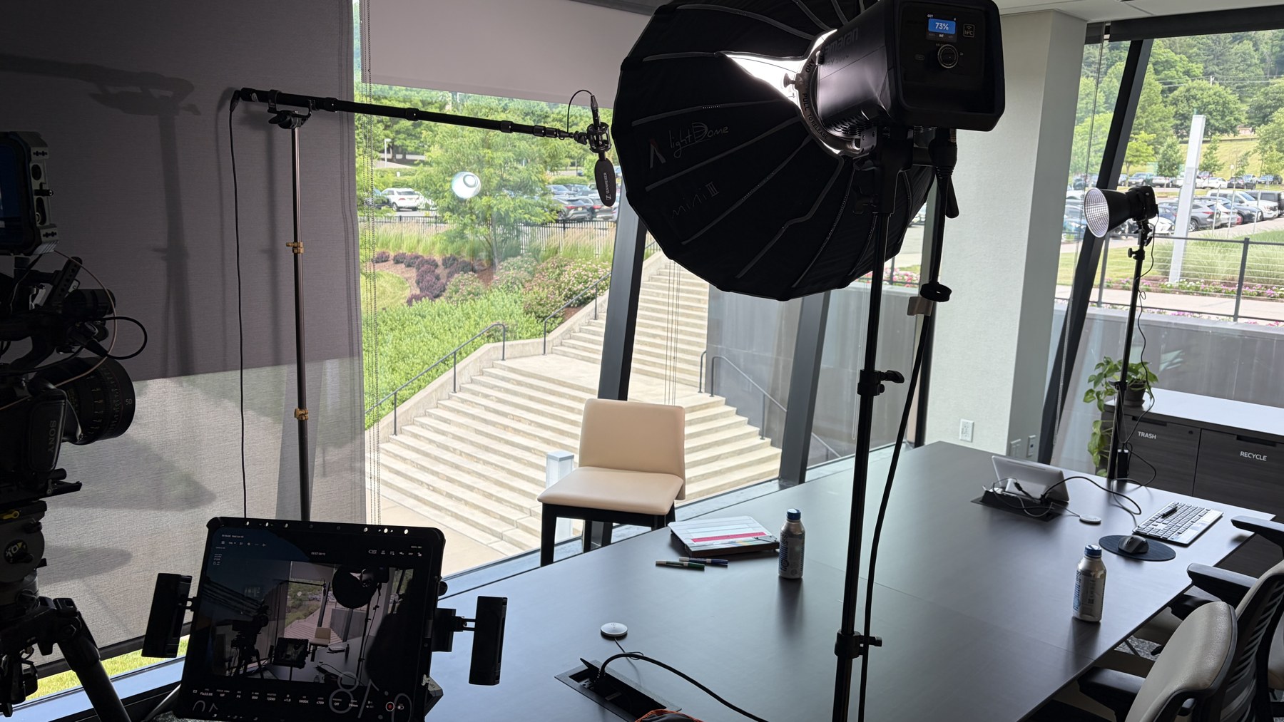 Behind-the-scenes lighting setup with diffusion, softbox, and edge light in a glass conference room