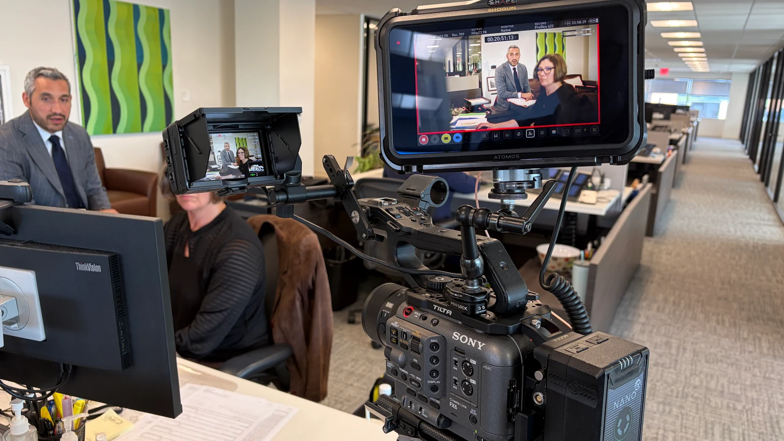 Behind-the-scenes view of a Sony cinema camera filming people inside an office