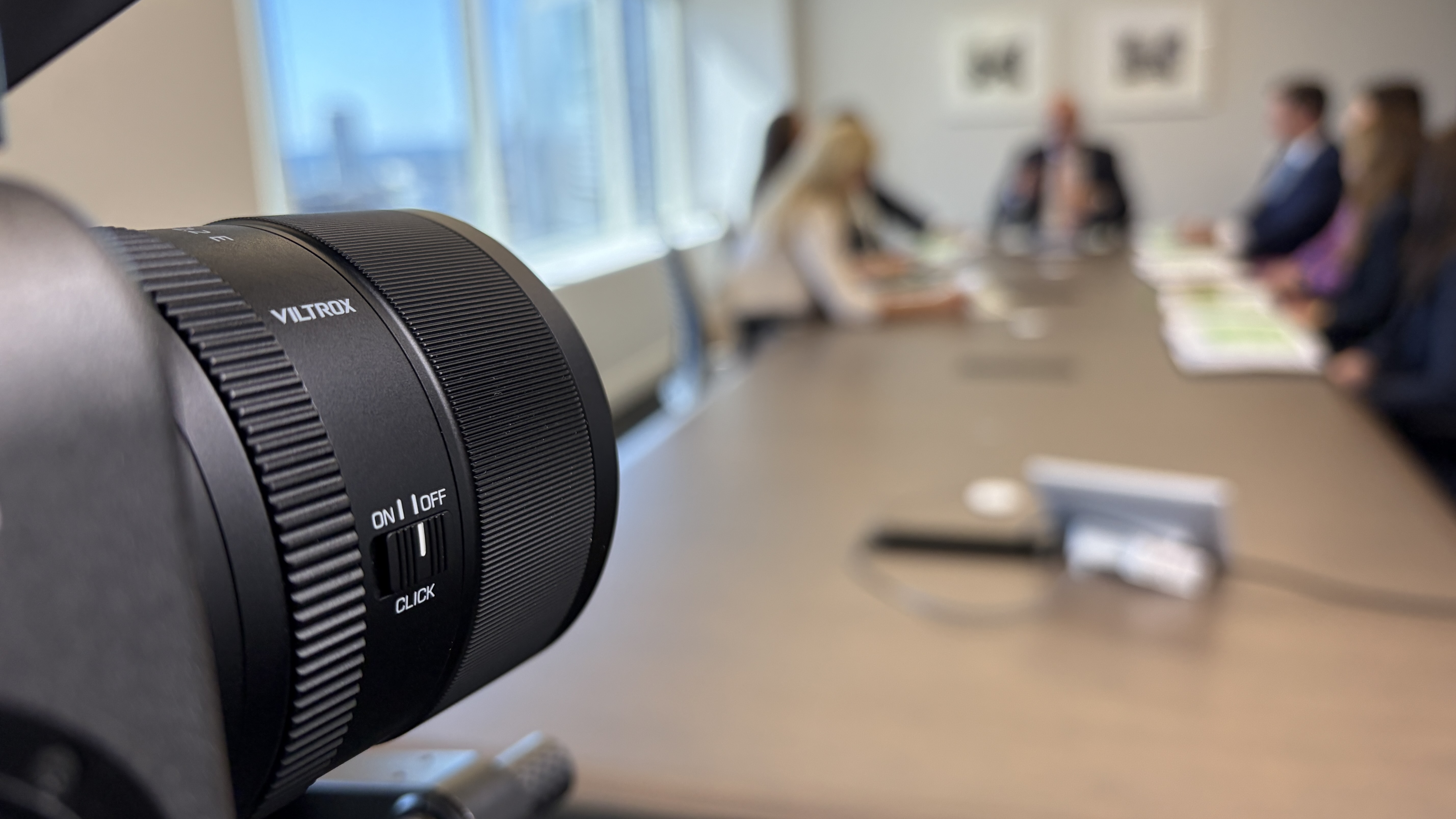 Viltrox 90mm filming a group around a conference-room table