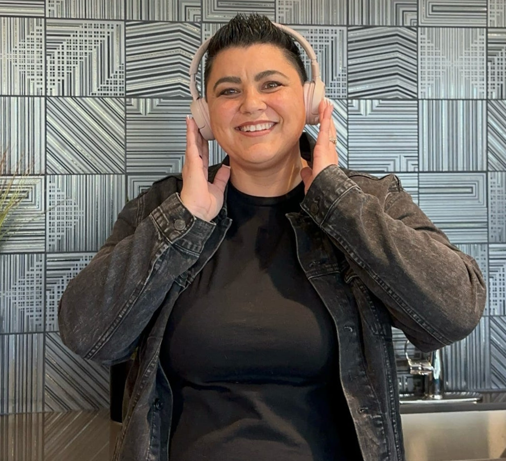 Andi Hess wearing headphones, smiling