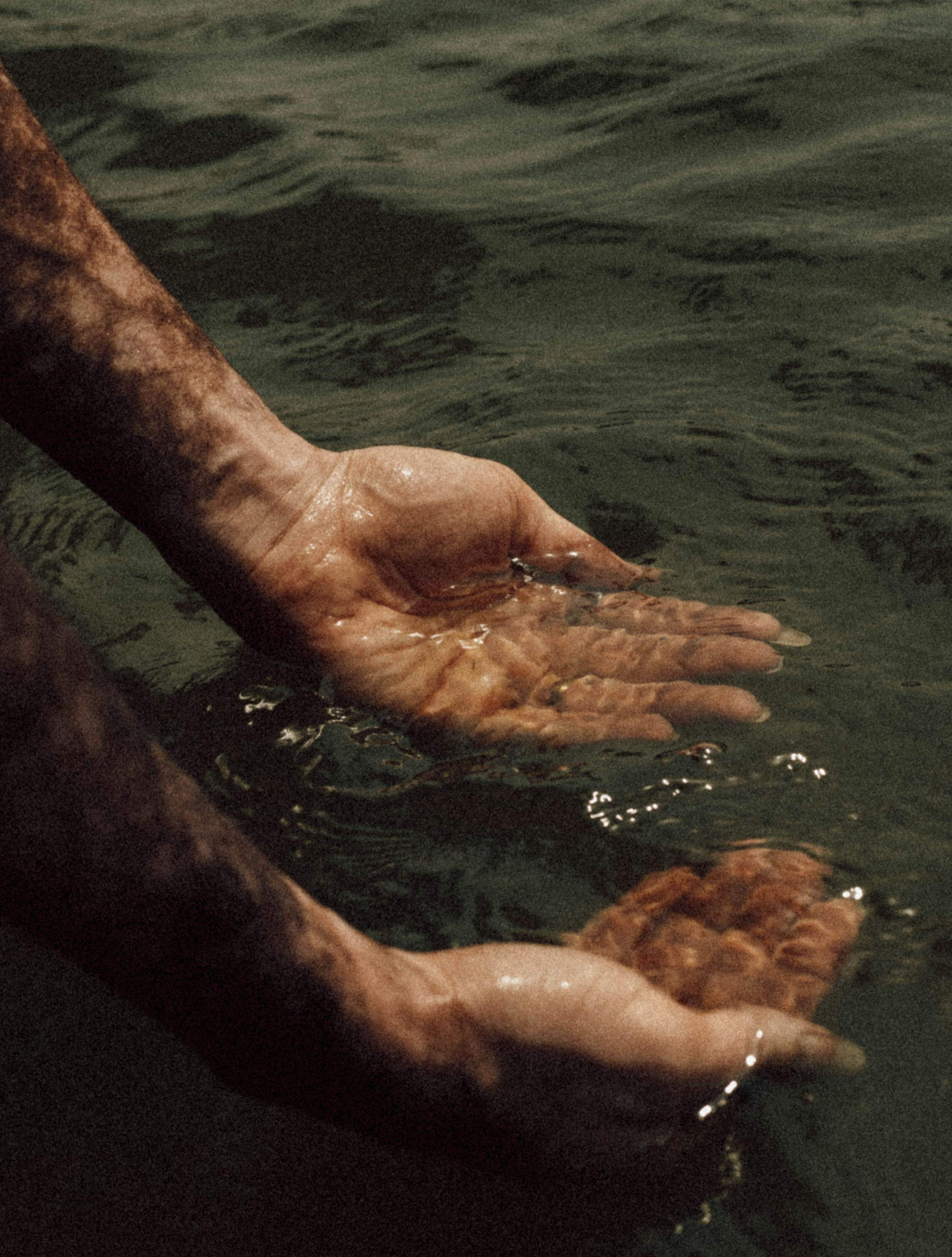 Open hands resting in still water
