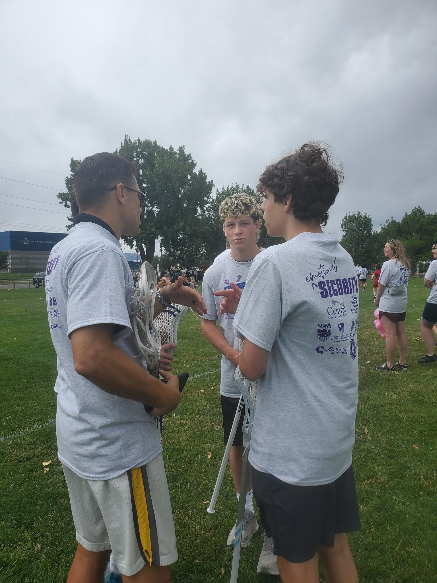 Aidan and Dean speaking with a community partner at the lacrosse event