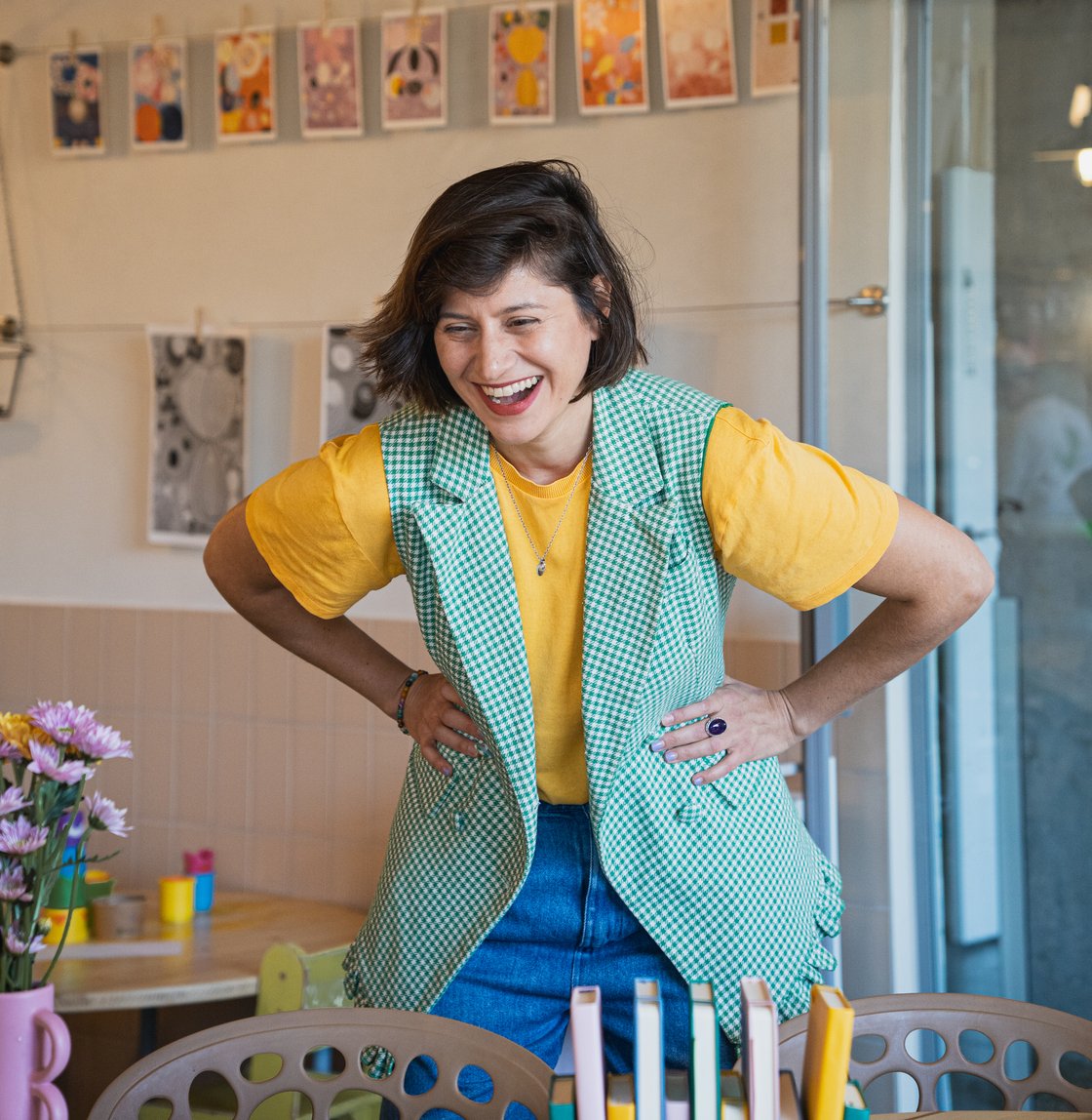 Bárbara Duhau riendo, con remera amarilla y chaleco verde
