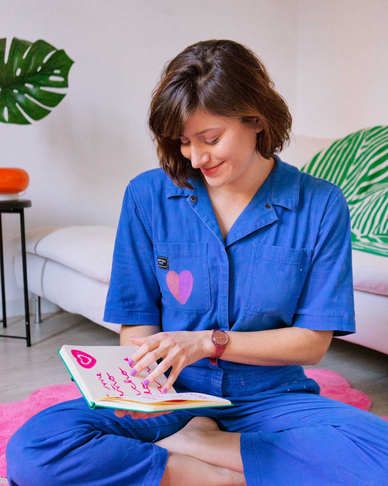 Bárbara leyendo un cuaderno, con mono azul