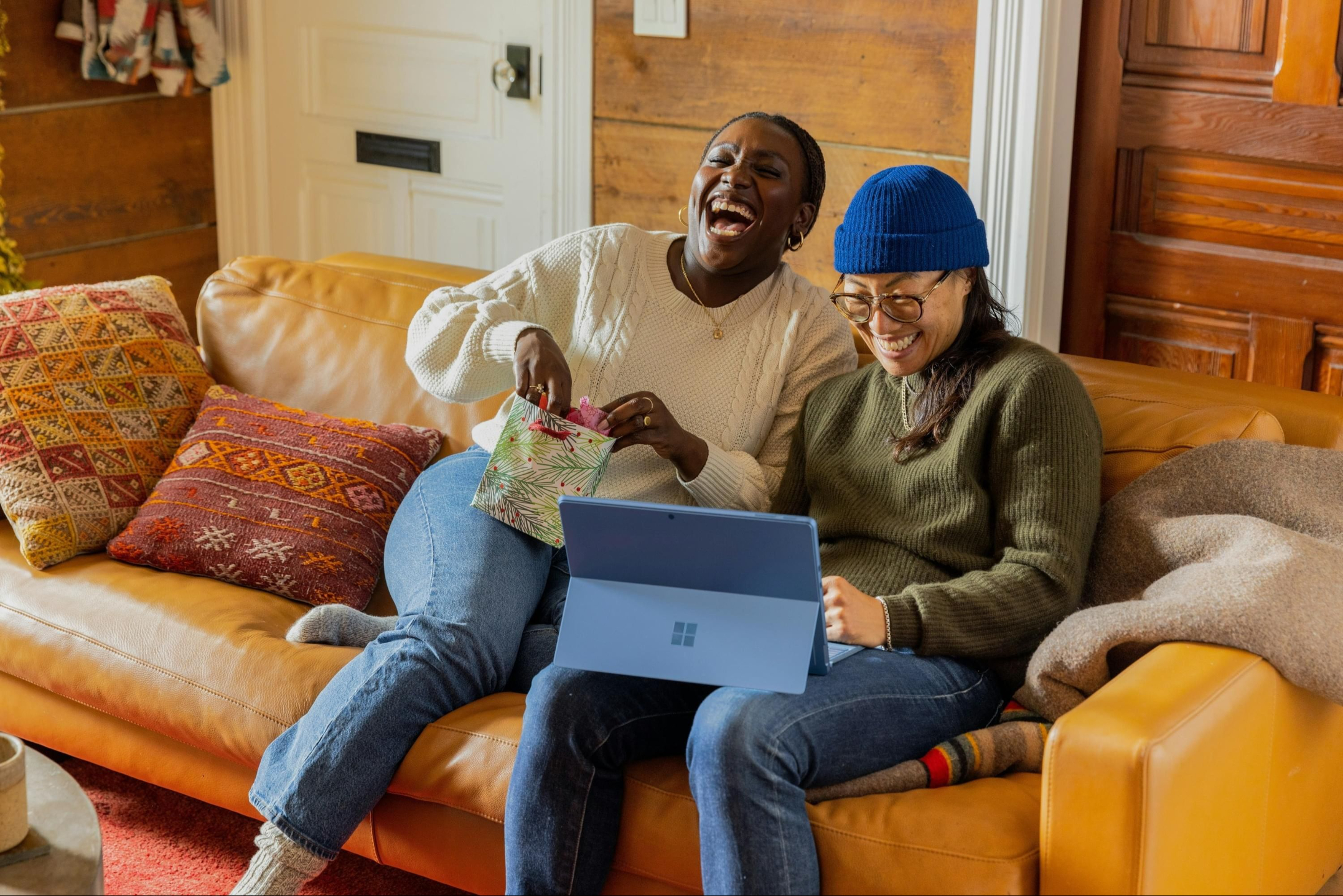 Couple laughing on couch with laptop