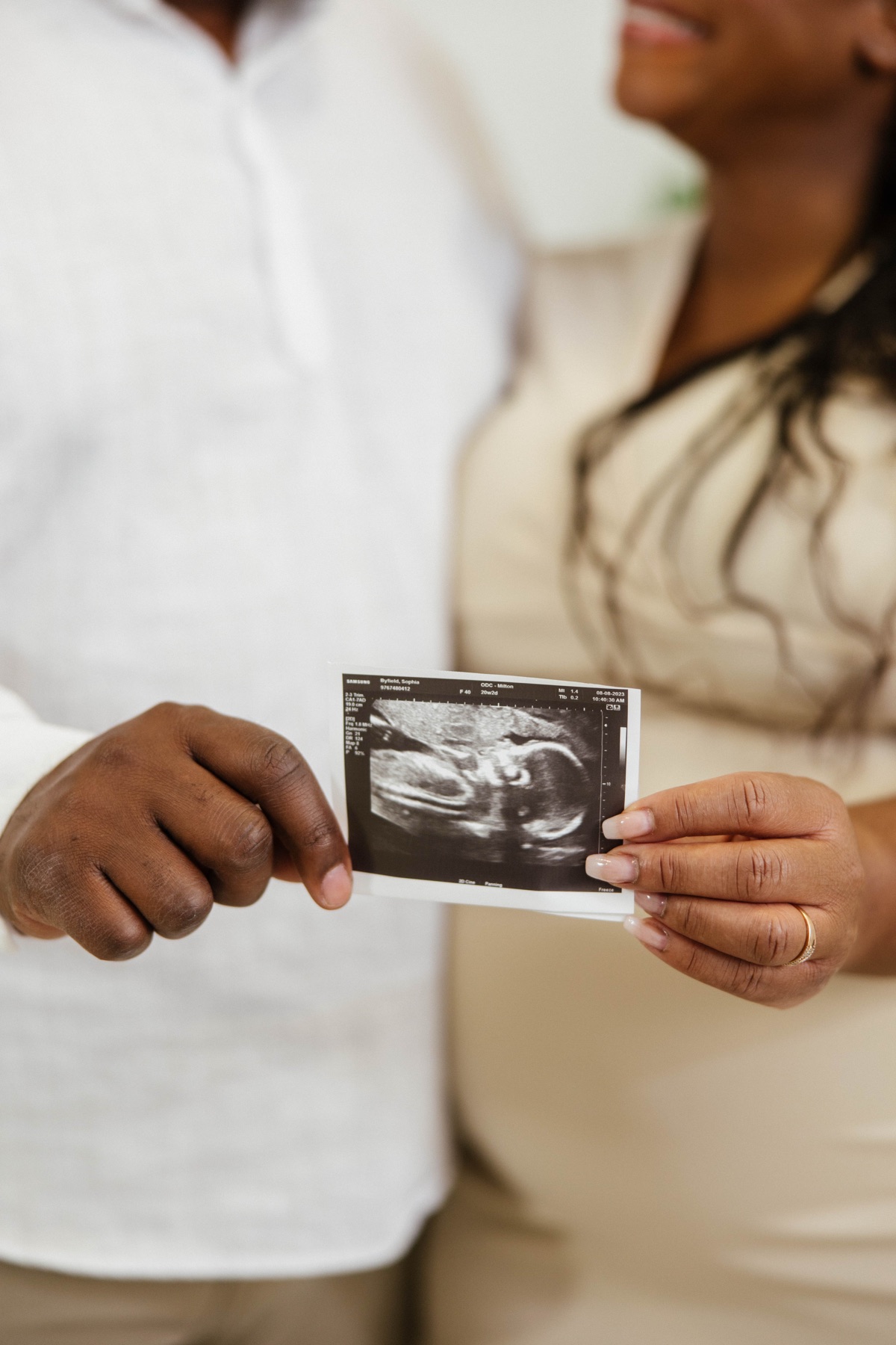 Sophie and her husband holding an ultrasound photo