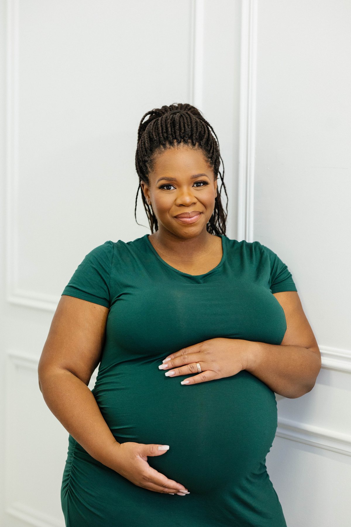 Fertility coach Sophie Byfield, pregnant, smiling in a green dress