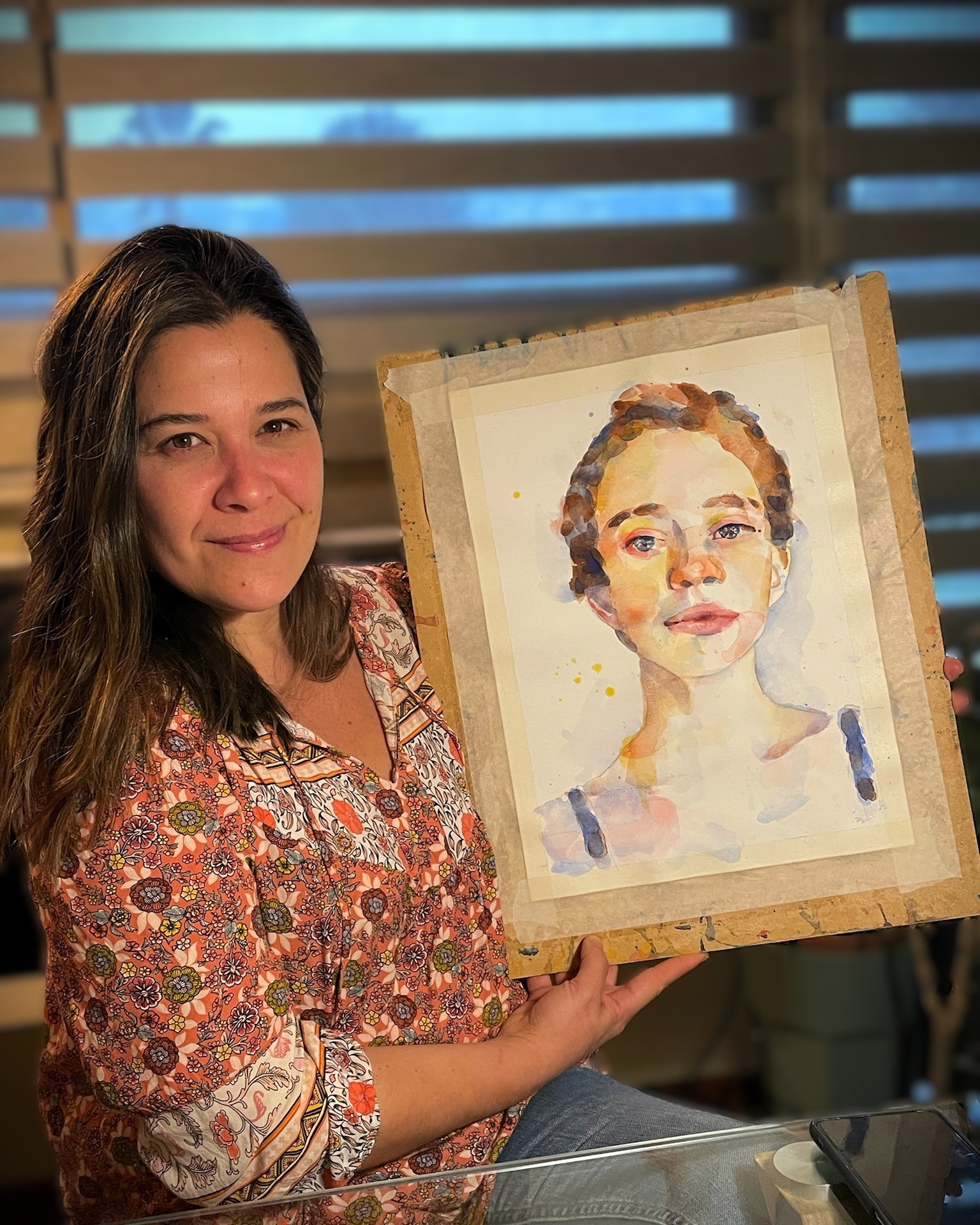 María Paz sosteniendo su retrato en acuarela