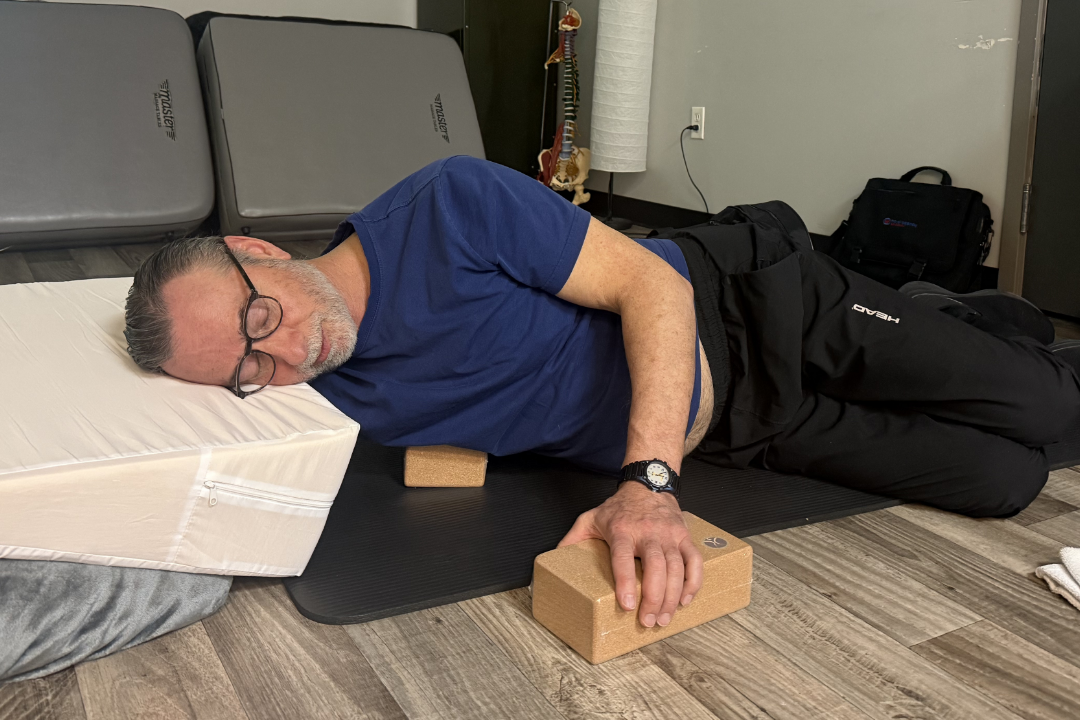 Therapist practising a forearm release over a cork therapy block