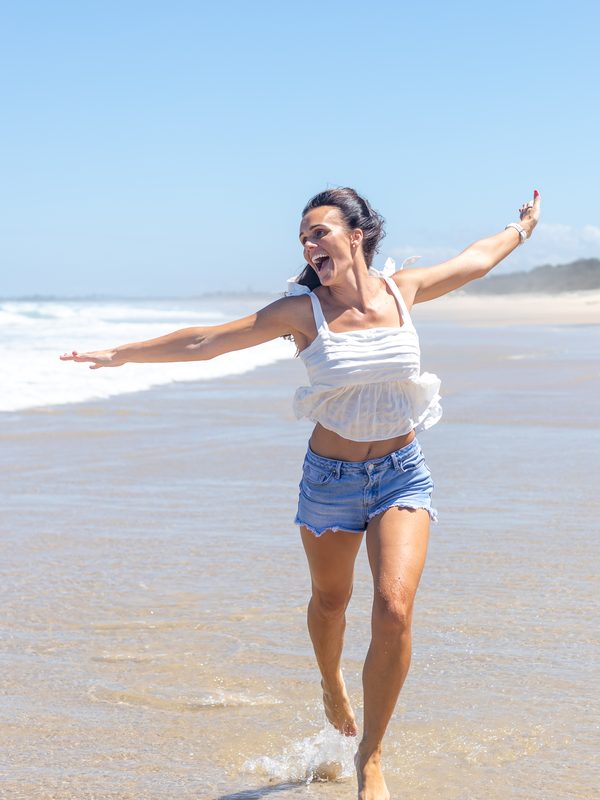 Hayley Ryan running through the shallows at a Sunshine Coast beach