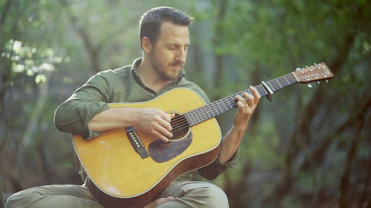 Todd Boston playing guitar in the forest