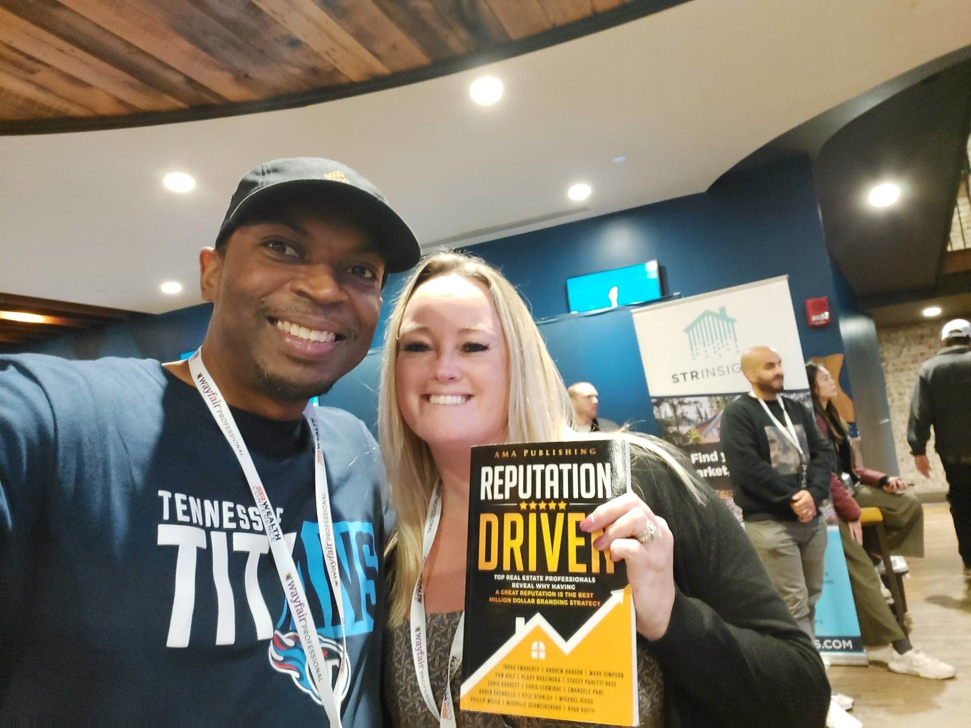 Judah holding a published book at an event