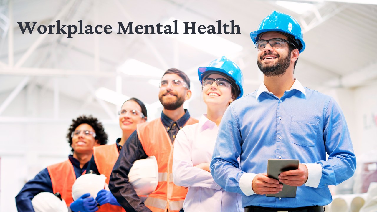 Diverse team of workers in hard hats and safety vests smiling together in an industrial workplace