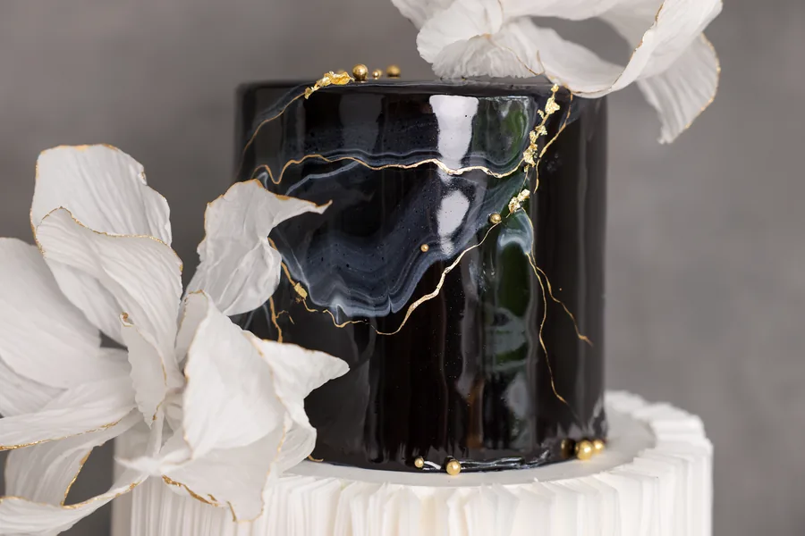 Gold kintsugi crack lines across black mirror gloss
