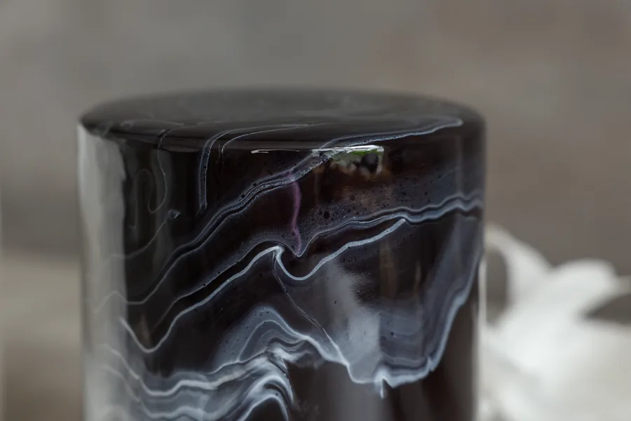 Close up of white marble swirls through black mirror gloss