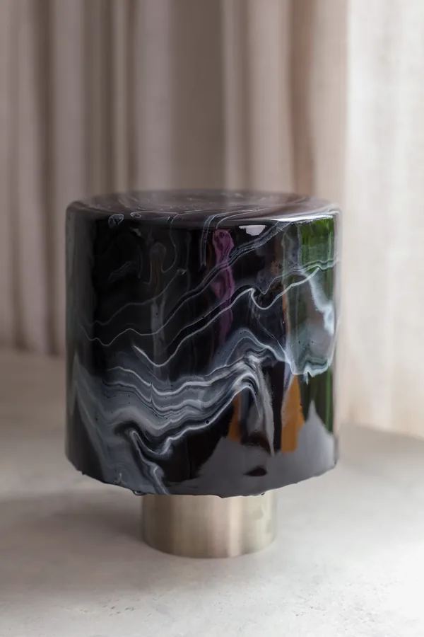 Tall black mirror gloss cake reflecting a window