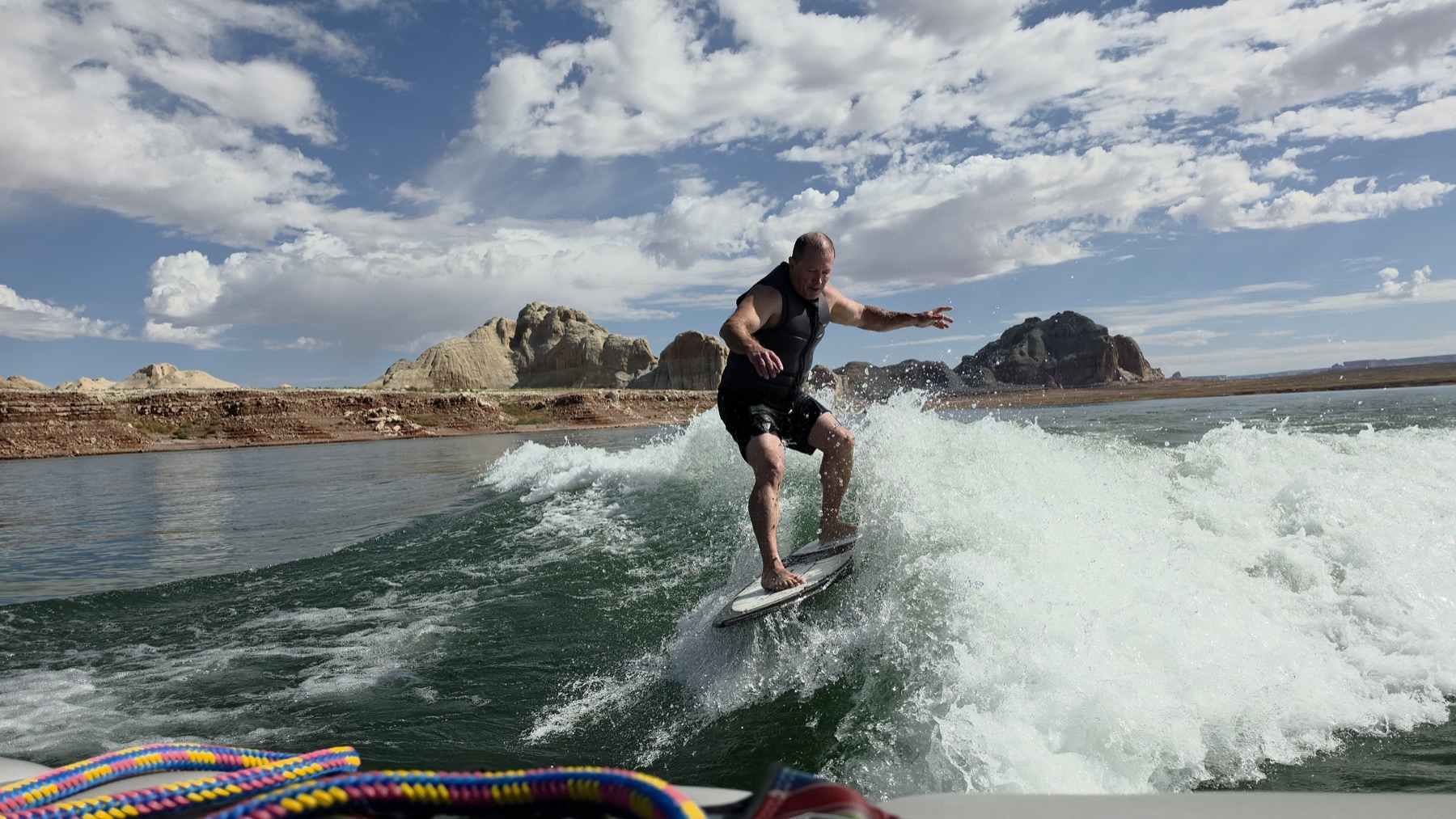 A Man Camp participant wakesurfing on Lake Powell