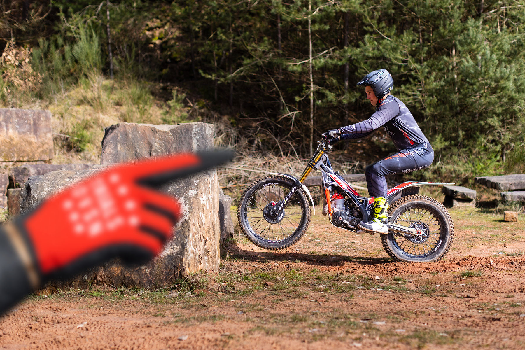 Coach pointing out the line while a trials rider approaches an obstacle