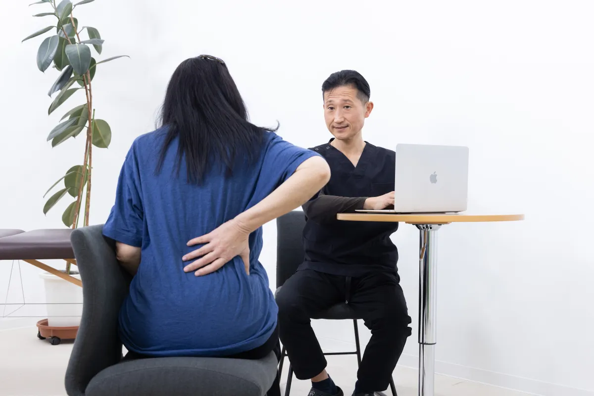 Sonobe speaking with a patient while observing posture