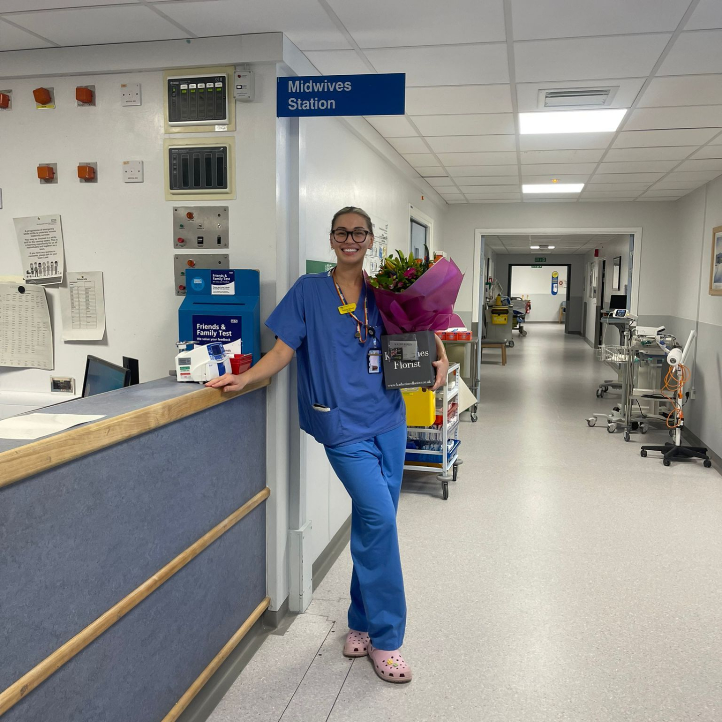 Sydney Graves in scrubs at the hospital Midwives Station