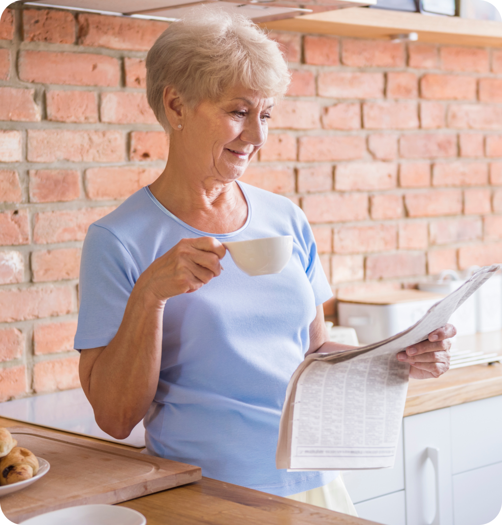 Older woman enjoying a coffee and newspaper