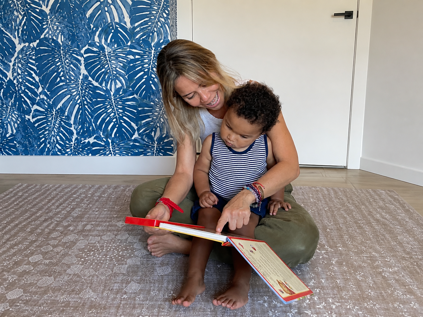 Caregiver and young child reading a book together