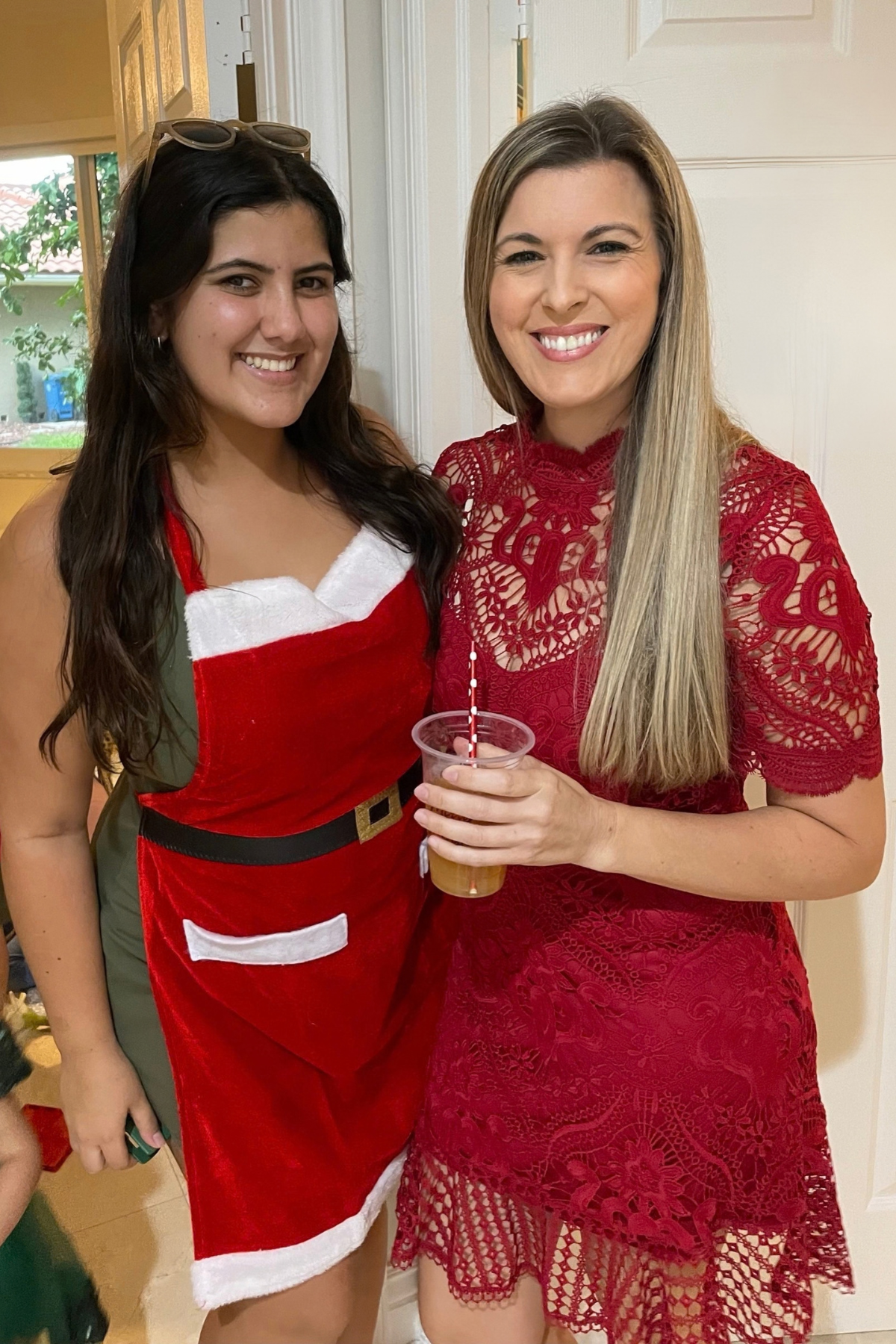 Two women smiling together at a holiday gathering