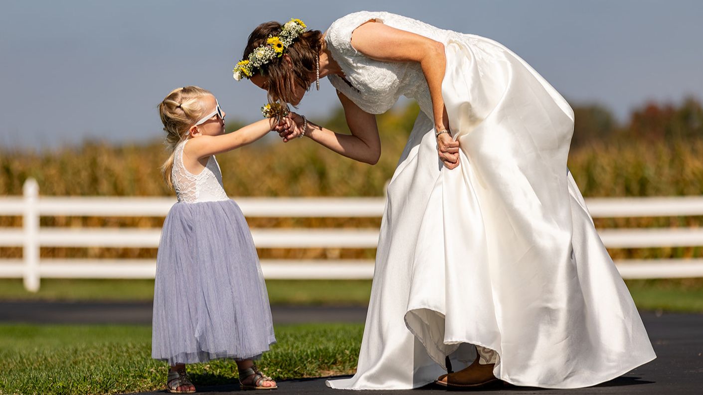 Bride and flower girl sharing flowers