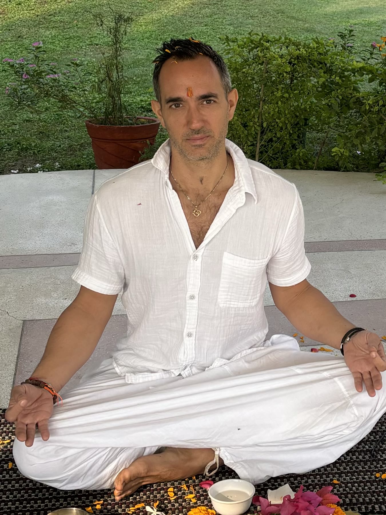 Grégory Tejaswi en Inde, assis en tailleur après une cérémonie