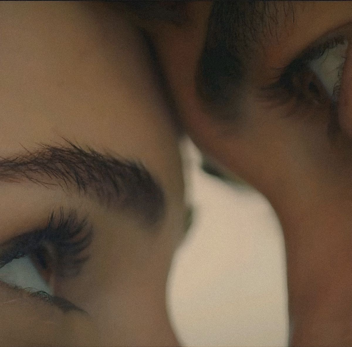 Two faces close together, eyes meeting