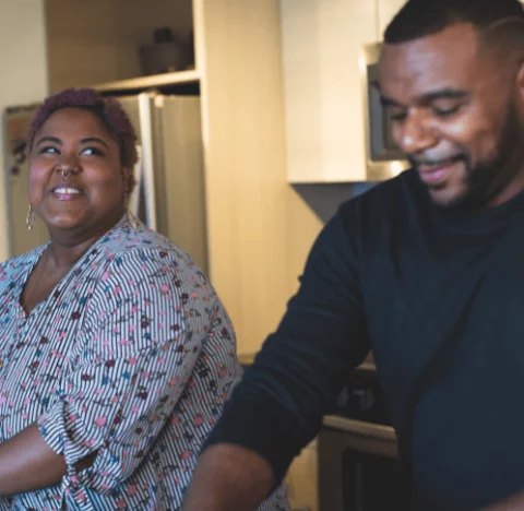 Two people smiling together in a clinic waiting room