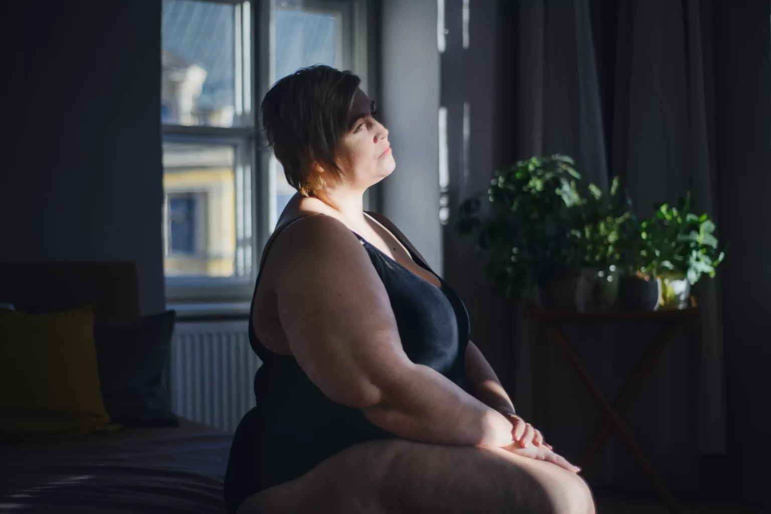 Person sitting by a window in soft light