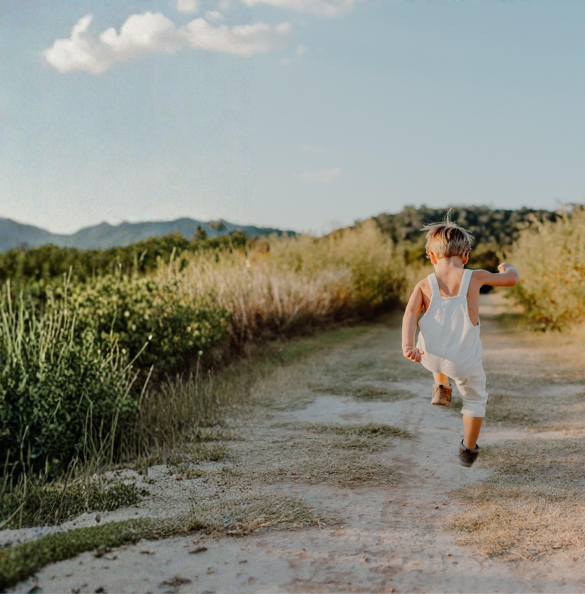 A child running down a sunlit path