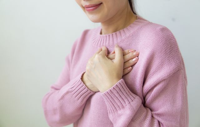 Woman with hand on chest, eyes closed