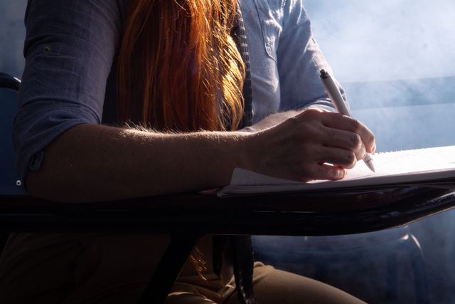 Person writing in a journal at a table
