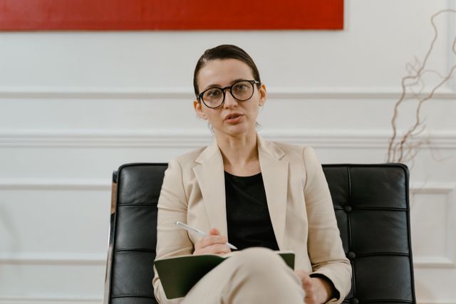 Facilitator sitting in a plant-filled room for a personal introduction video
