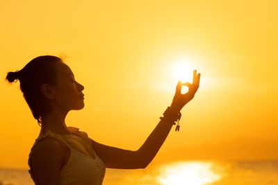 Woman meditating at sunset