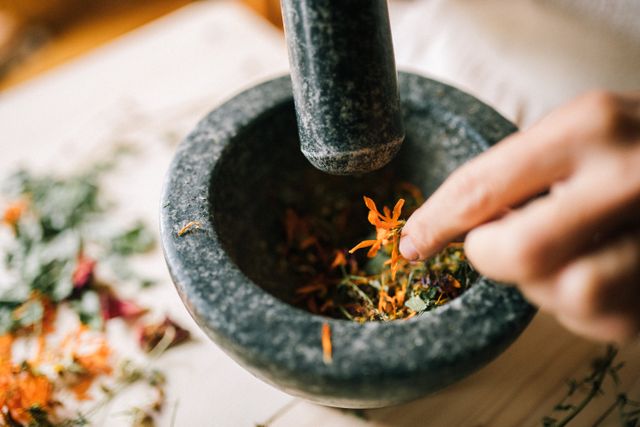 Mortar and pestle with fresh herbs and spices